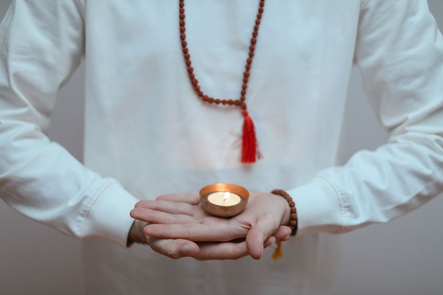 Person holding a candle during meditation, promoting peaceful ambiance and mindfulness.